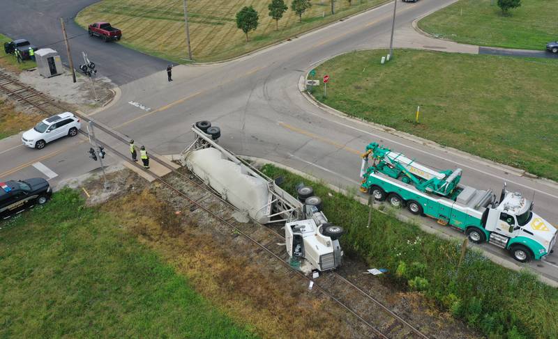 Wallace firefighters work the scene of an overturned sand hauler at the intersection of North 15th Road and U.S. Route 6 on Wednesday, July 9, 2025 in Ottawa. The semi overturned on the train tracks. La Salle County Sheriff and Ottawa Police assisted with the crash.