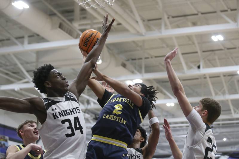 Yorkville Christian's Kayden Maxwell (2) is defended under the basket by Kaneland's Jeffrey Hassan (34) during their Plano Christmas Classic Championship basketball game between Yorkville Christian at Kaneland Tuesday, Dec 30, 2025 in Plano.