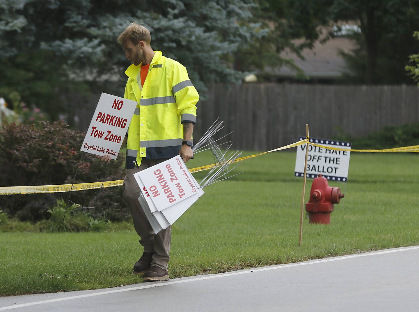 A worker, from the Crystal Lake Department of Public Works,  puts up no parking signs alone Country Club Road  on Tuesday, July 2, 2024, before the start of the Lakeside Festival at the Dole. The festival runs from July 4, through July 7.