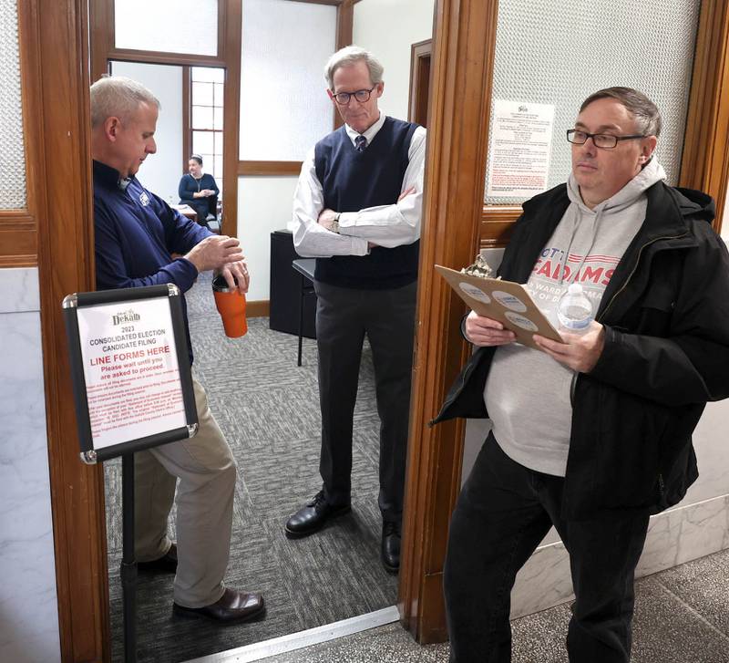 DeKalb City Council Ward 5 alderman Scott McAdams (right) waits for candidate filing to begin as mayor Cohen Barnes (left) checks his watch and city manager Bill Nicklas prepares to open Monday, Dec. 12, 2022, at City Hall. McAdams, who is running for re-election, was among the first candidates in line Monday at 8:30 a.m. when filing opened at City Hall.