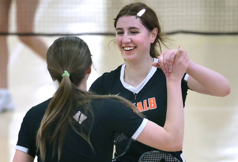 DeKalb’s Lea Guelde (left) and her partner Kaitlyn Davis celebrate winning game one Friday, May 12, 2023, during their doubles match against Joliet Central at the IHSA State Badminton Finals at DeKalb High School.