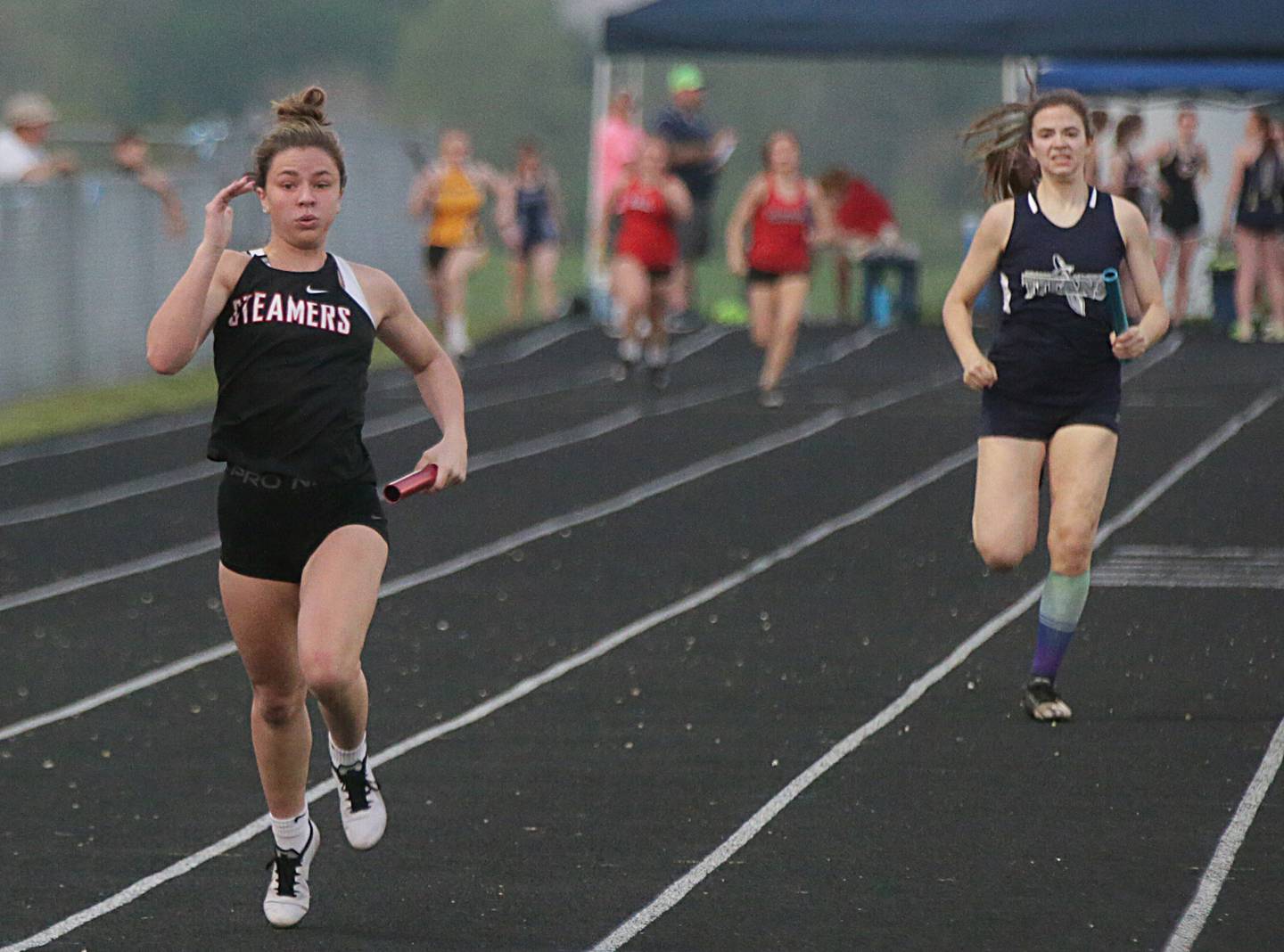 Fulton's Lauren Mahoney wins the 4x200 relay as Kewanee Wethersfield's Madison Rusk takes second in the Class 1A Bureau County Sectional held Wednesday, May 11, 2022, in Manlius.