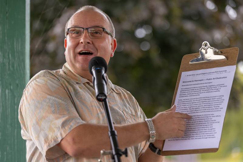 Hennepin Mayor Quentin J. Buffington welcomes guests to the unveiling of the "Grazing Cattle" sculpture at the river front on September 20, 2025 in Hennepin.