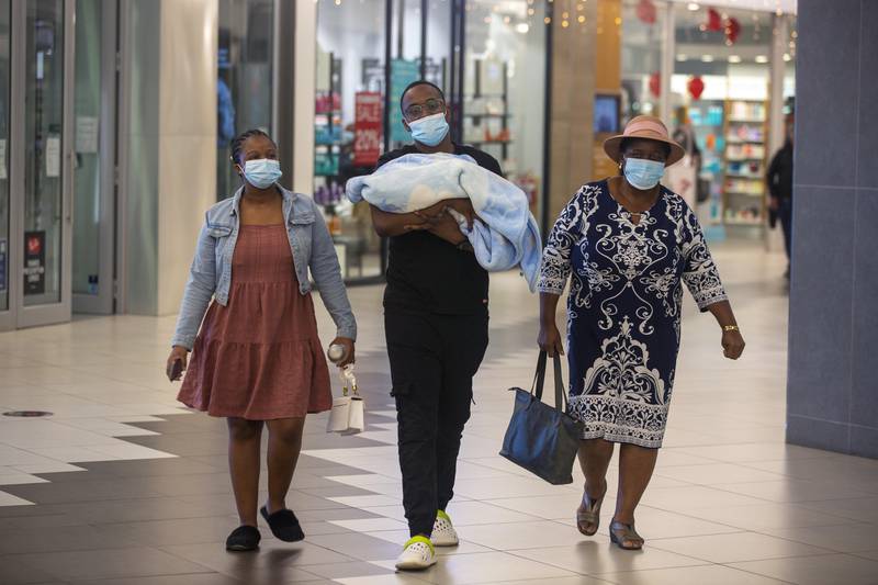 People with masks walk, at a shopping mall, in Johannesburg