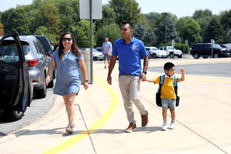 Four-year-old Sebastian Salinas walks with his parents, Candelaria Galvan and Edgar Salinas, during the first day of school for the Geneva Early Learning Program on Monday, Aug. 21, 2023.