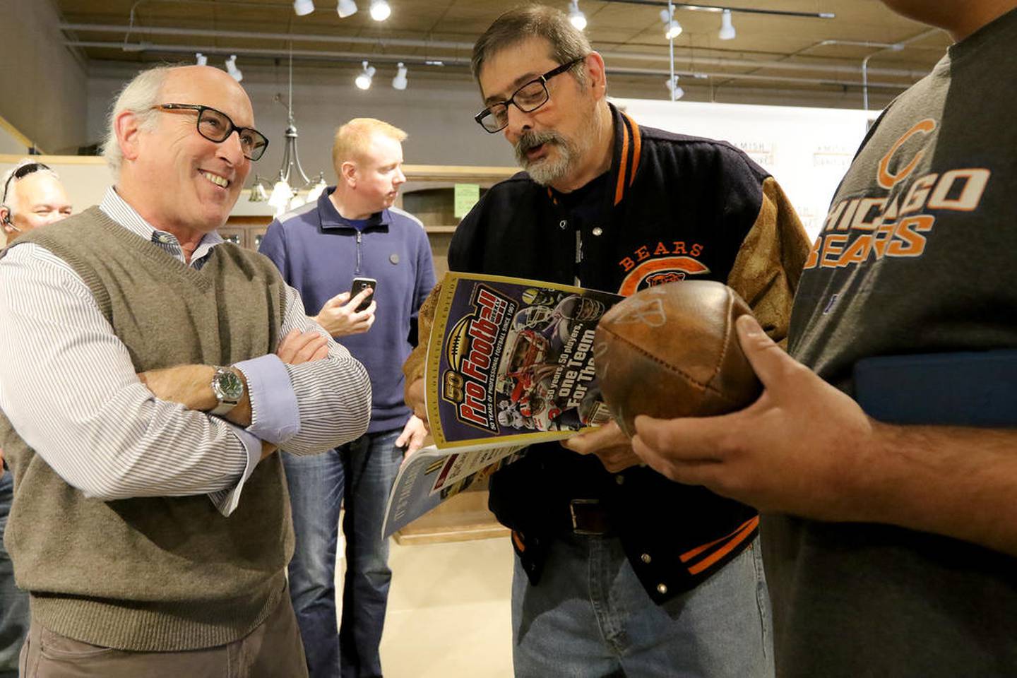 Pro Football Weekly's Hub Arkush talks with Bears fans during an autograph session with Bears Hall of Famer Dan Hampton on Saturday at Amish Furniture Gallery  in Crystal Lake.