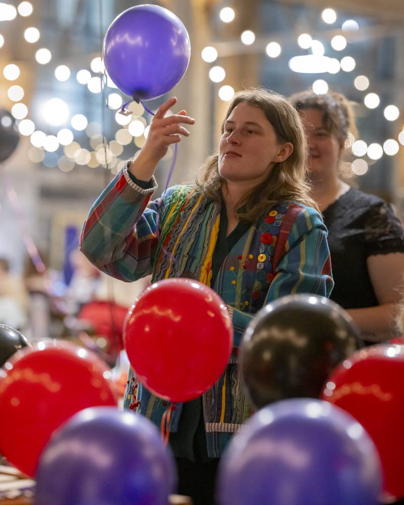 Emily Maze picks out a balloon to be popped as part of a prize winning fundraiser at the Mad Hatter Ball on January 17, 2024 at the Westclox Event Center.