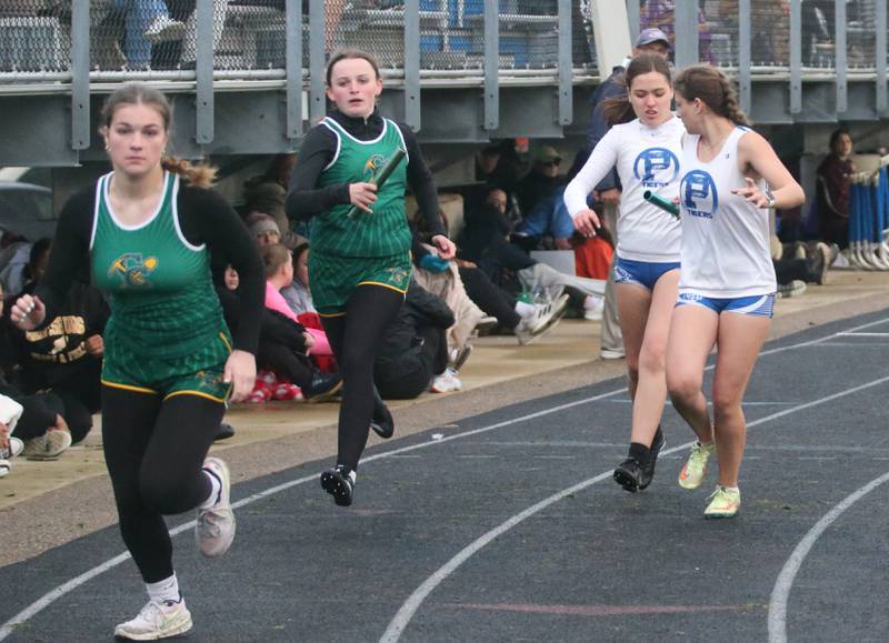 Coal City's Isabella Bartholomew hands the baton to teammate  Madelybn Castel as Princeton's Georgie Fulton hands her baton to Princeton's Scarlet Fulton in the 4x200 meter relay during the Class 2A girls track and field Sectional on Thursday, May 9, 2024 in Princeton.