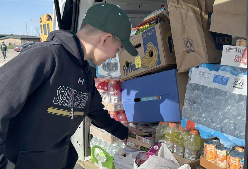 Payton Davis of Utica, drops donated cake boxes into a packed van full of donations to the Hall Township Food Pantry greets fans before the game between Hall and St. Bede baseball on Monday, March 31, 2025 at Schweickert Stadium in Peru. Teams collected items totaling 1,179 pounds of food.