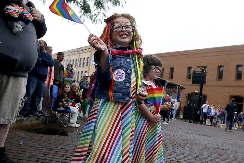 Sloane, 6, and Charlotte, 4, Idstein of MccHenry waves their flags as they watch the Woodstock PrideFest Parade Sunday, June 11, 2023, around the historic Woodstock Square.