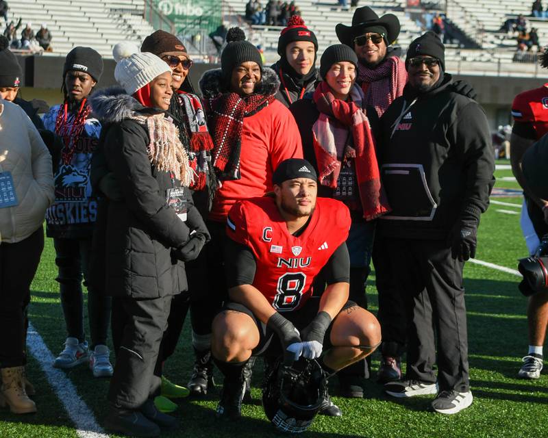 Northern Illinois University’s Devonte O’Malley poses for a photo with family and Northern Illinois Huskies head coach Thomas Hammock during senior day on Saturday Nov. 30, 2024, before the start of the game against Central Michigan held at Huskie Stadium in DeKalb.