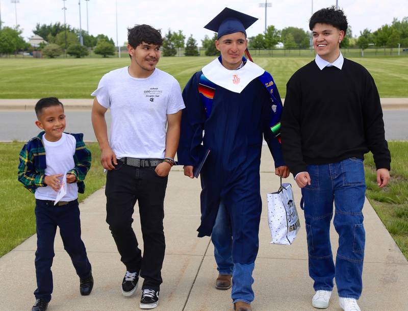 Oswego High School graduate Angel Moreno (in cap & gown) walks out with his family (left to right) Hugo Moreno, Bryan Adame and Victor Vera after the Oswego High School Class of 2024 Commencement Ceremony on Saturday, May 18, 2024 in DeKalb.