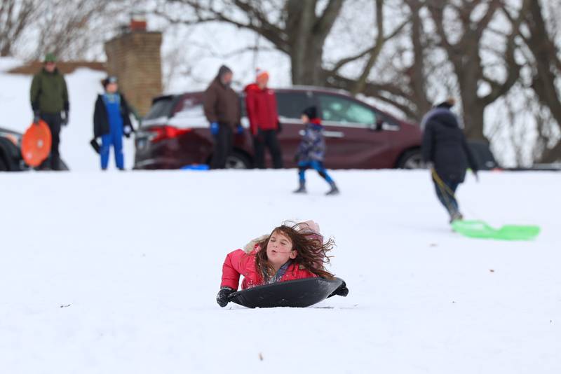 Viviana Villafuerte, 6, of Grundy County, leaps onto her sled at Helgeson Park in Bradley on Sunday, Nov. 30, 2025.