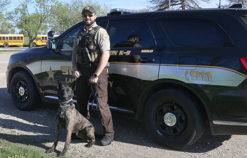 Bryant Eustice poses for a photo with K-9 Miko on Friday, April 19, 2024 at St. Bede Academy in Peru.