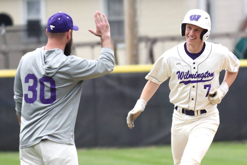 Wilmington's Cooper Holman, right, is congratulated by coach Mike Bushnell as he rounds third base following his home run during a home game against Manteno Tuesday, April 21, 2026.