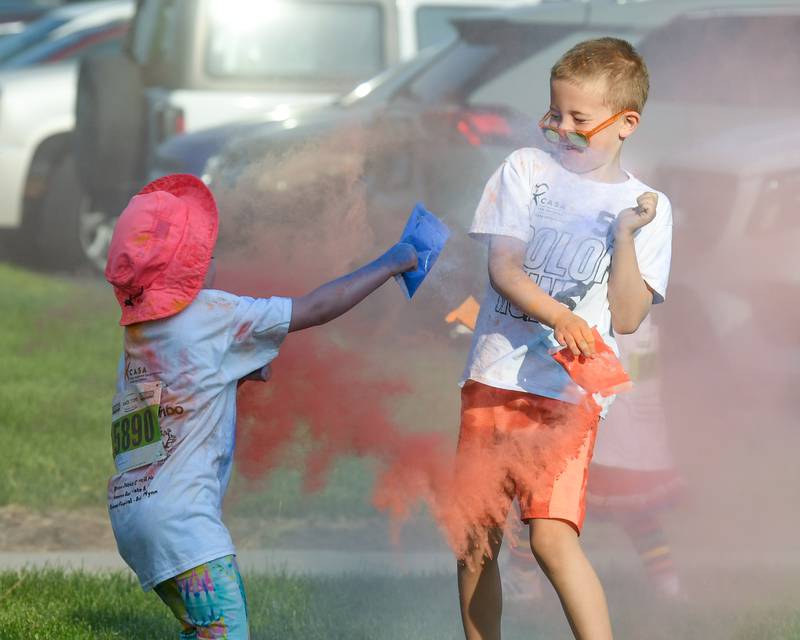 Cousins Nelson Reineck 7, and Grace Peterson, 5, both of Sycamore throw color powder at each other before the start of the CASA DeKalb County 5K Color Run on Saturday, June 7, 2025, held at Sycamore Middle School.