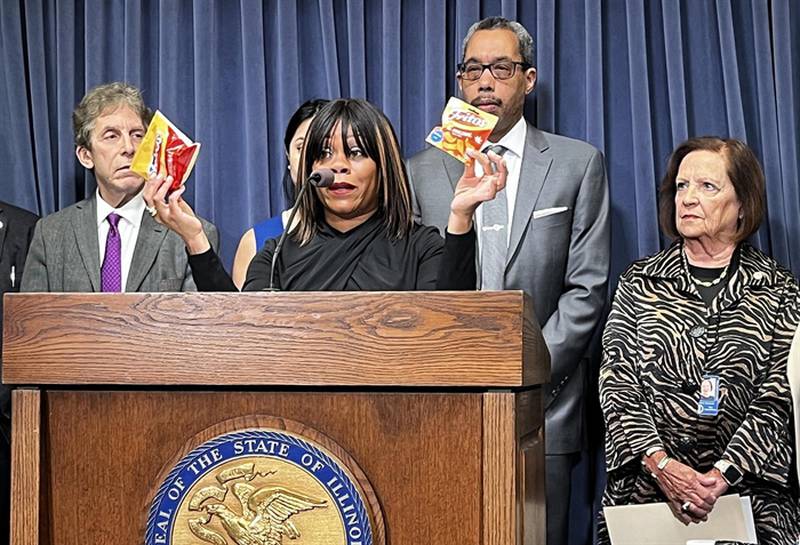 Cannabis Business Association of Illinois Executive Director Tiffany Ingram holds up a bag of Fritos corn chips and a similar-looking bag of “Fritos” snacks with small cannabis leaves on it. CBAI is urging for the state to prohibit sales of delta-8 THC products like the imposter “Fritos.”