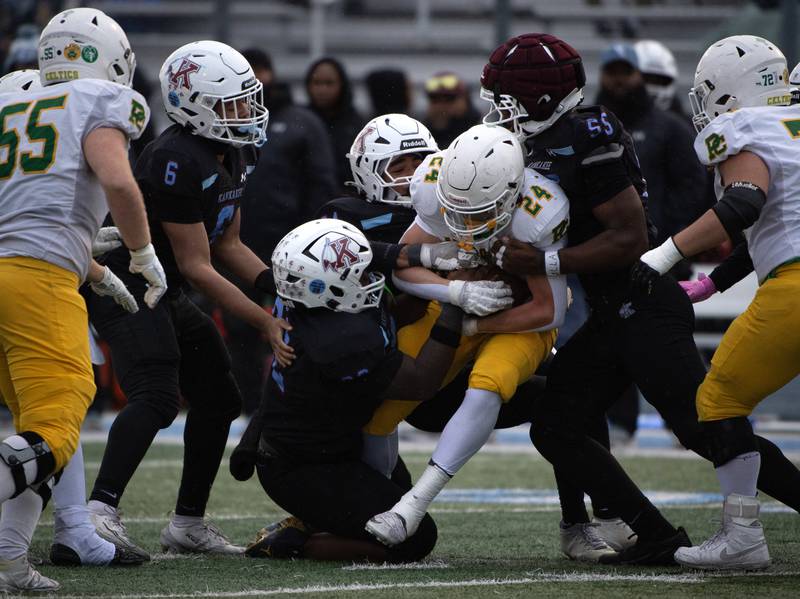 Providence Catholic's Broden Mackert, center, carries the ball on a play as a pack of Kankakee defenders bring him down during a Class 5A playoff game on Saturday, November 8, 2025.