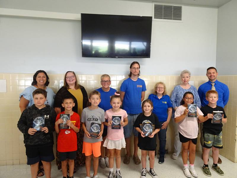 Putnam County third grade students posed with their new personal dictionaries presented Sept. 19, 2024, to them by PC Rotarians. Pictured (from back, left) PCES Principal Courtney Balestri, Rotarians Karen Karczewski, Sue Motley, Matt Miller, Club Literacy Chair Adriane Shore, Club President Cheri Adrian and School Superintendent Clay Theisinger.