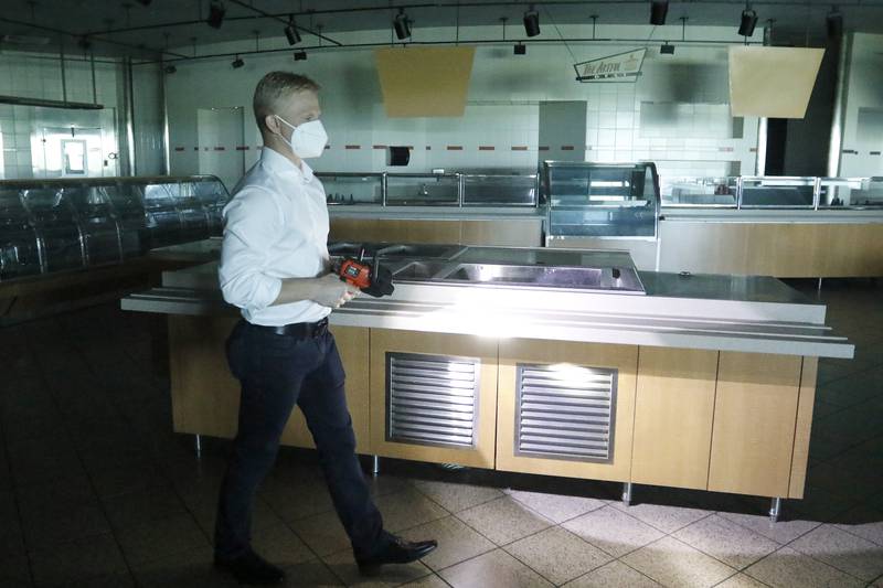 Sean Stofer, COO of Green Data Center Real Estate, Inc., uses a high-powered flashlight as he walks through the cafeteria on the property at the former Motorola headquarters on Thursday, June 10, 2021 in Harvard.
