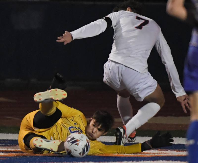 Lyons Township goalkeeper Tyler Balon scrambles to control the ball as Naperville North’s Noah Radeke tries to get in position in the Class 3A state soccer semifinal game in Hoffman Estates on Friday, November 3, 2023.