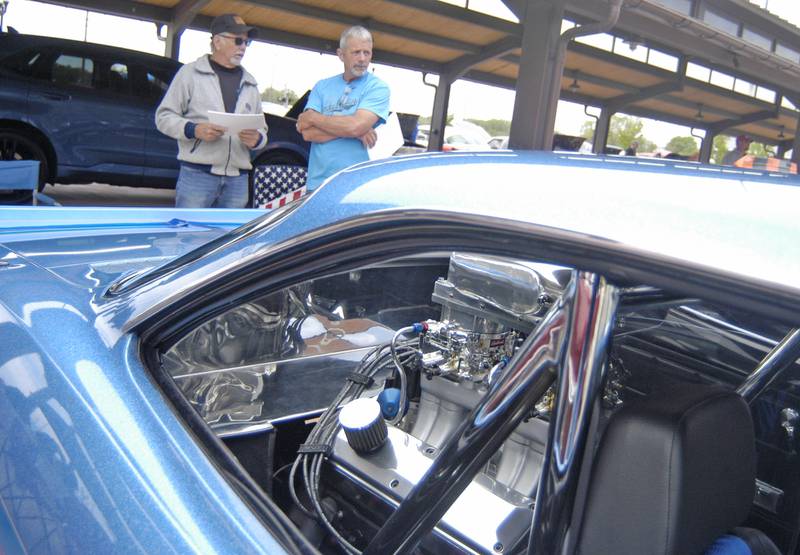 Rick Long and Steve Reuter discuss Reuter's rear engine Corvair. Sterling Main Street's 12th Annual Car Show took place at the Sterling Marketplace on Sunday, May 4th, 2025.
