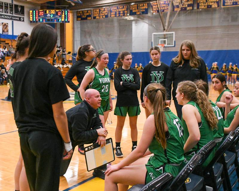 York head coach Brandon Collings, kneeling, talks to the team before the start of the second quarter Friday Feb. 3rd as they took on Lyons Township High School while traveling to Lyons Township High School.