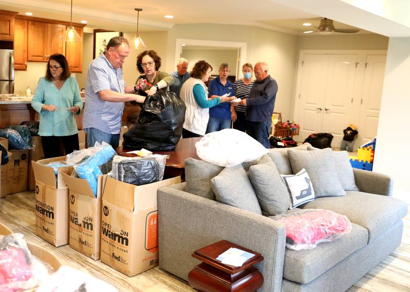 Volunteers sort children’s winter coats to be donated to the Salvation Army, Lazarus House and area schools.