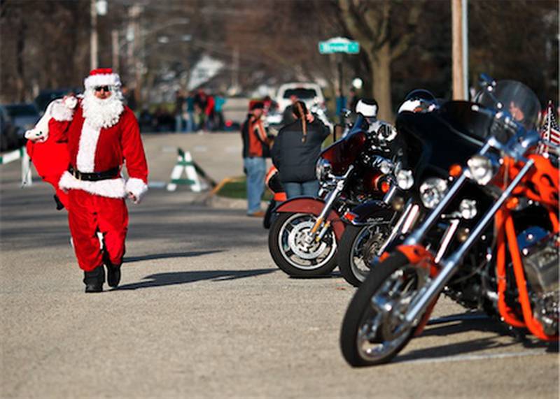 Dressed as Santa, J.J. Adams of Wonder Lake walks with a bag of toys to be donate after the Toys For Tots Christmas parade in McHenry.