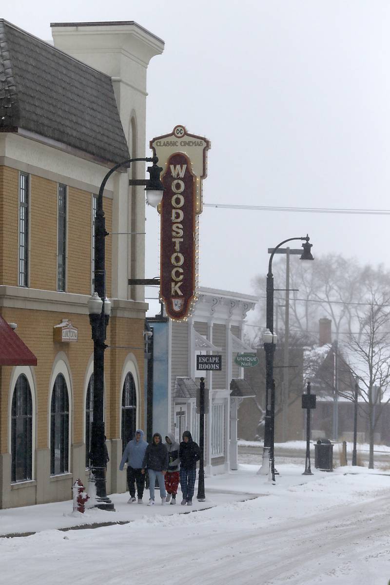 A group of boys walk to the Classic Cinemas Woodstock Theatre on Thursday, Feb. 16, 2023, in Woodstock after winter storm moved through McHenry Count, creating hazardous driving conditions.