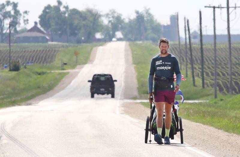 Tom Boerman, from the Netherlands, walks west on Old State Road near Kirkland Tuesday, May 24, 2022, hoping to make it to Rockford by the end of the day. Boerman, who stopped for the night at a home in DeKalb, is on a quest to walk around the world while raising money for schools in Nepal that were hit hard by the 2015 earthquake in the region.