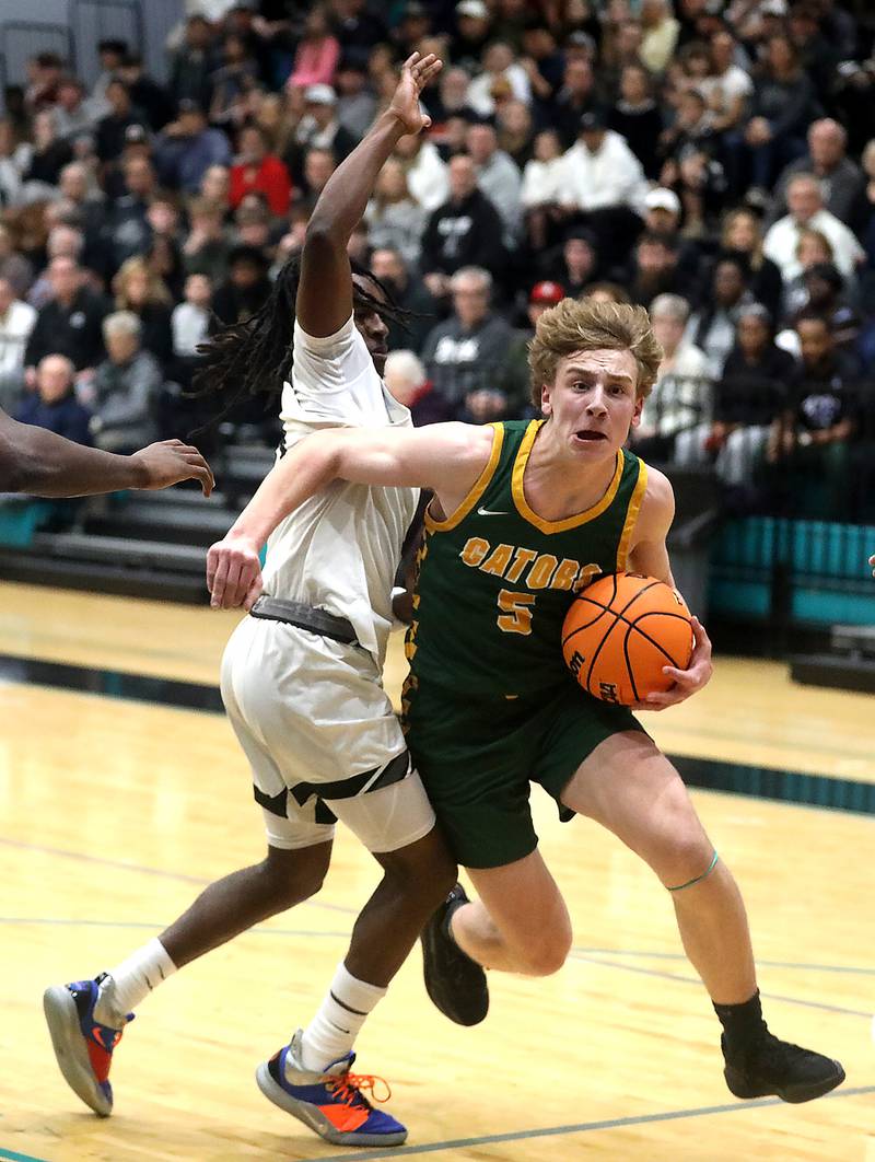 Crystal Lake South's Carson Trivellini tries to drive to the basket against Kaneland's Marshawn Cocroft during the IHSA Class 3A Woodstock North Sectional final basketball game on Friday, March 6, 2026, at Woodstock North High School.