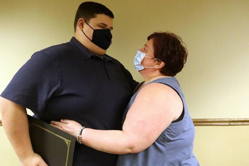 Danny Brezina gets a hug from his mother, Missi, after reading an Autism Awareness Proclamation during a board meeting at Cary Village Hall on Tuesday, April 6, 2021 in Cary.  This was the third year Brezina, a senior with autism at Cary-Grove High School, was offered the opportunity to deliver the proclamation during a village board meeting in Autism Awareness month.