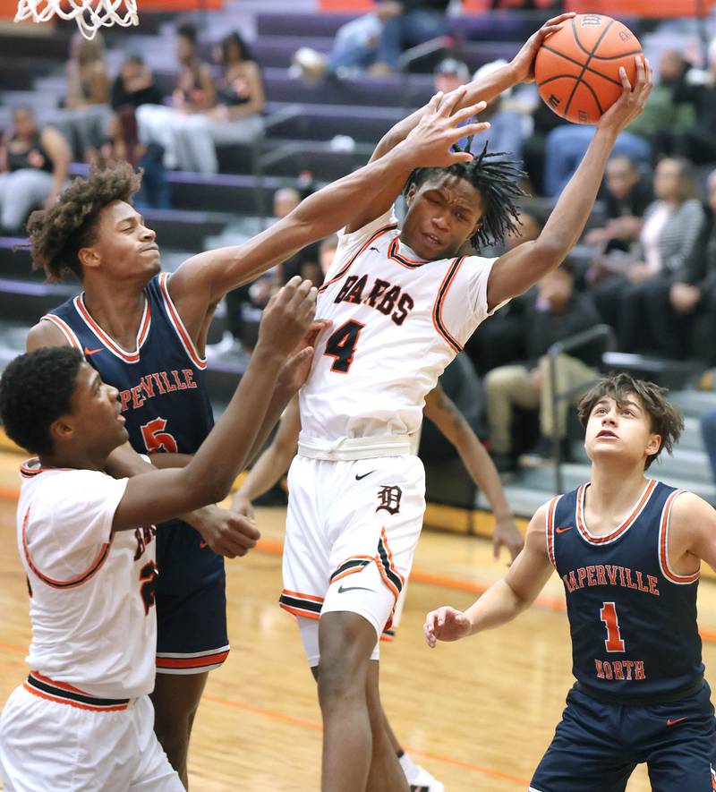 DeKalb's Johnny Henderson grabs a rebound in front of Naperville North's Luke Williams during their game Monday, Jan. 30, 2023, at DeKalb High School.