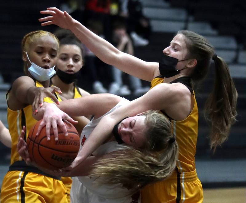 McHenry’s Alyssa Franklin, center, gets tied up with Jacobs’  Mackenzie Leahy, right, and Janaya Banks, left, during varsity girls basketball at McHenry Tuesday night