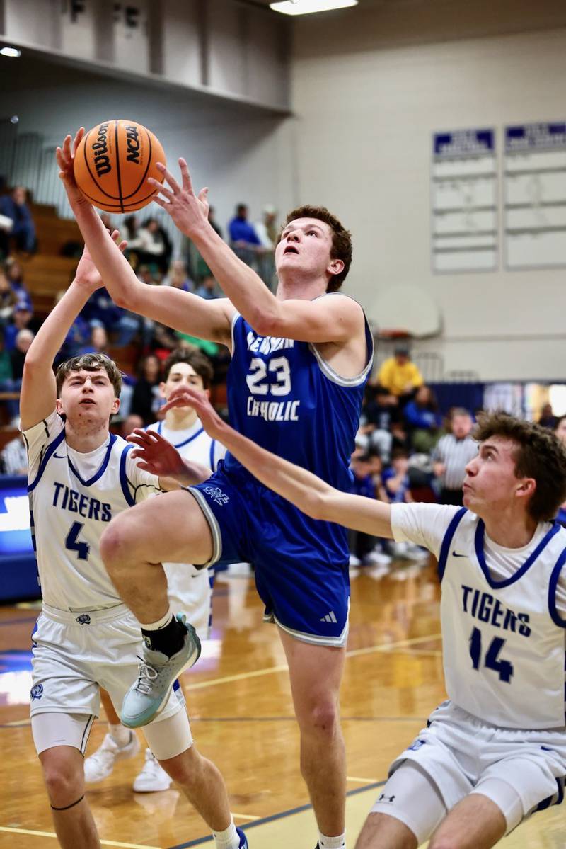 Newman's John Rowzee shoots between Princeton's Julian Mucha and Jackson Mason Saturday night at Prouty Gym.