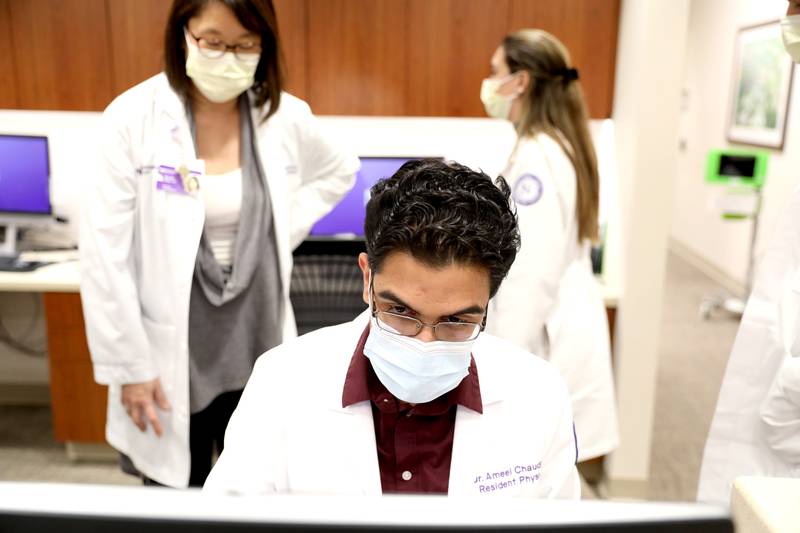 Ameel Chaudhary, who is in his first year in the Northwestern Medicine Delnor Hospital residency program, works in the program’s clinic with Director Natalie Choi (left) on Thursday, Dec. 15, 2022 in Geneva.