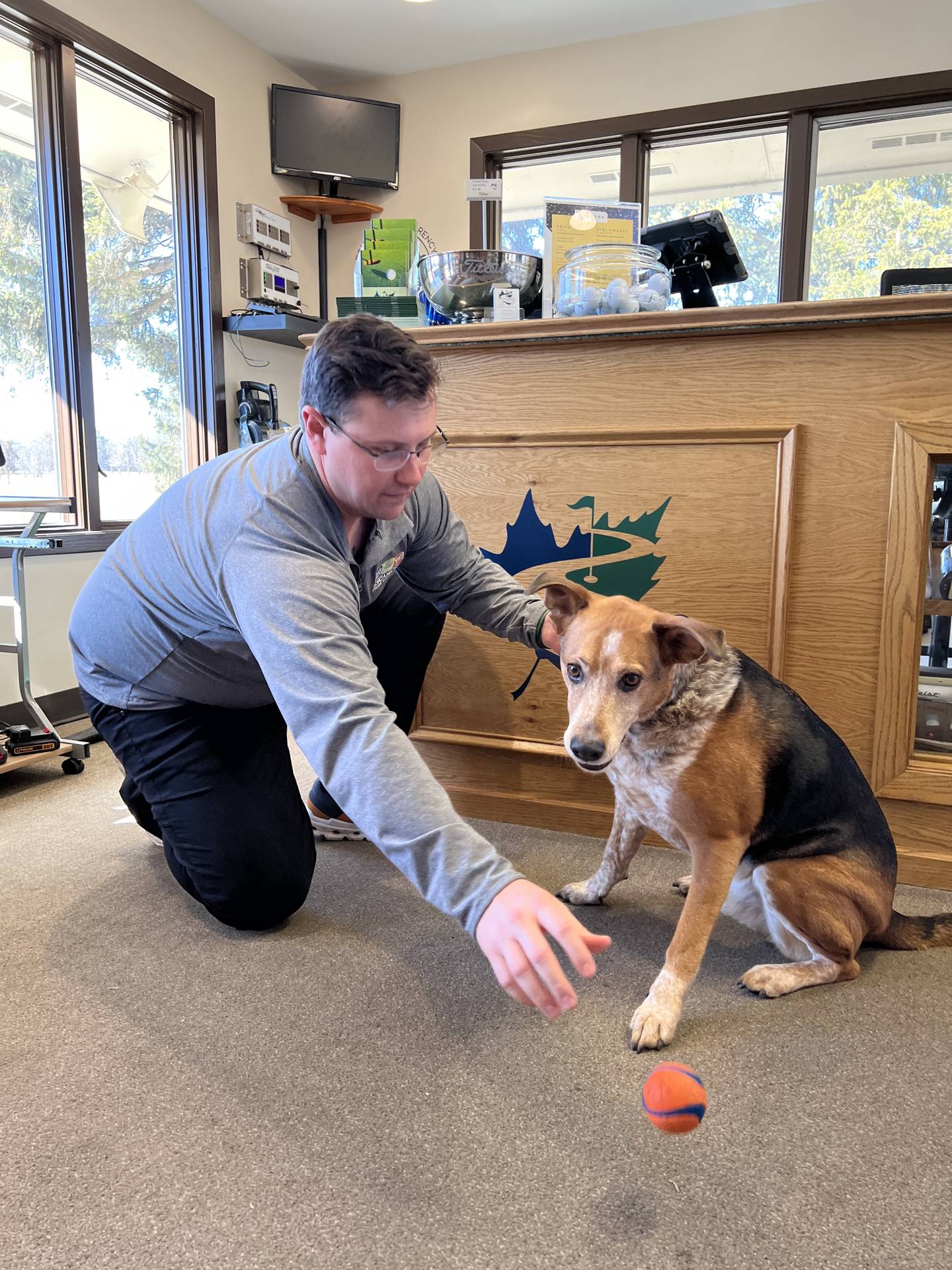 Paul Price, superintendent of golf services for the Sycamore Park District's Golf Club, plays with his dog Boone, inside the club's pro shop on Feb. 15, 2024.