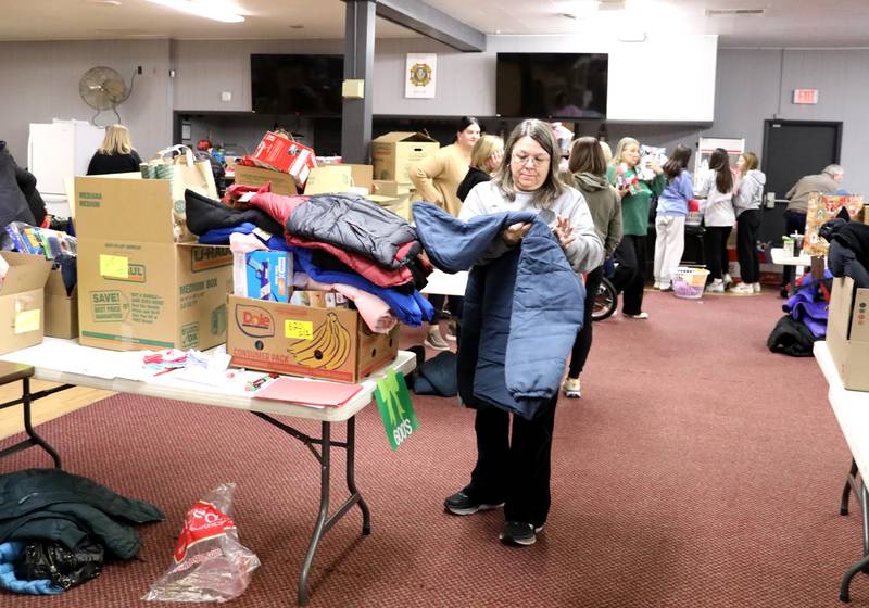 Volunteer Julie Parkhurst adds winter essentials to a donation box as part of the Batavia United Way Adopt-A-Family program.