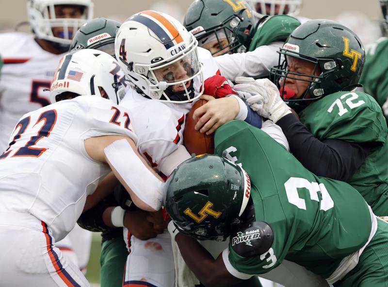 Oswego's Drew Kleinhans (4) is stood up by the Lane Tech defense during the varsity football second-round 8A playoff game between Oswego and Lane Tech on Saturday, Nov. 8, 2025 in Chicago.