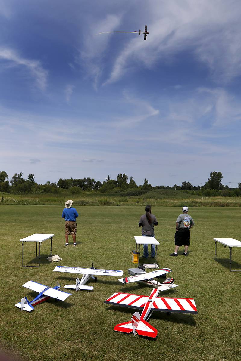 Club members, Larry Erbac, Joe McGinley, and Bill Mielke watch one of their place fly by on Thursday, Aug. 8, 2024. They were flying radio-controlled planes with other members of the Chain-O-Lakes Eagles R/C Club near Hebron.
