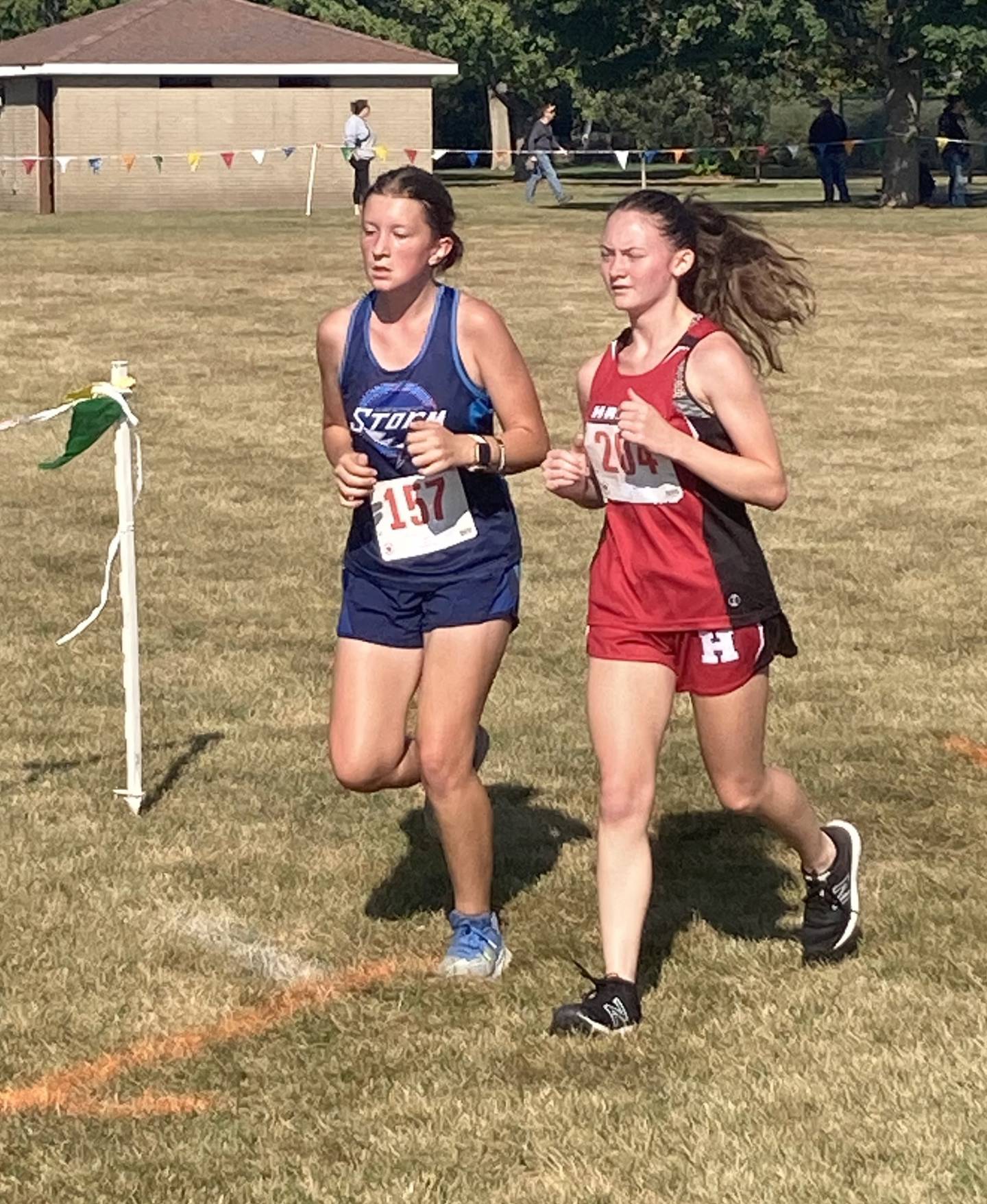 Bureau Valley's Leah House (left) and Hall's Jade Wangelin run in Saturday's Gary Coates Invitational.