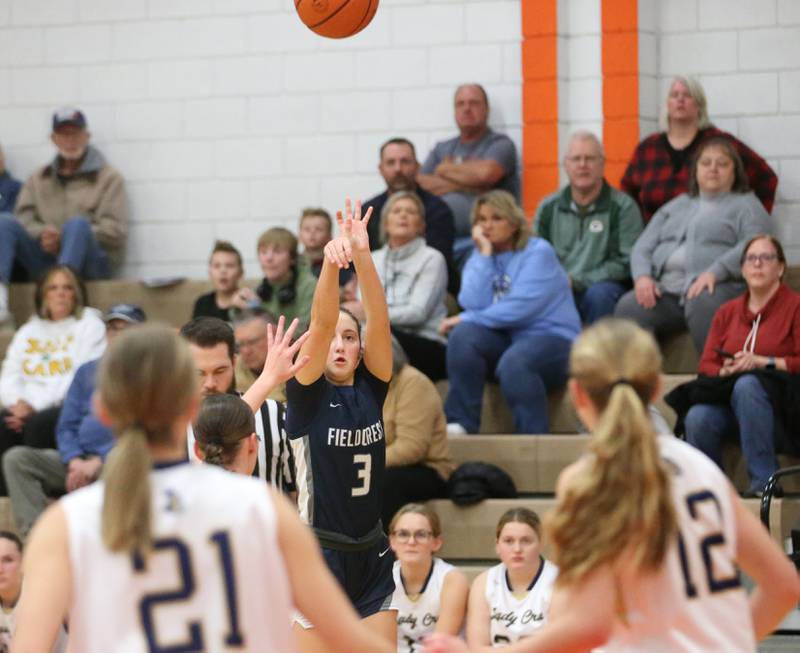 Fieldcrest's Macy Gochanour shoots a three-point basket over Marquette's Avery Durdan and Lilly Craig during the Integrated Seed Lady falcon Basketball Classic tournament on Monday, Nov. 13, 2023 at Flanagan High School.