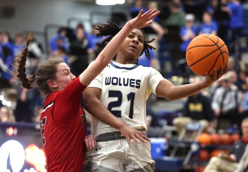 Oswego East's Desiree Merritt goes to the basket against Yorkville's Elaine Gussman during their game Tuesday, Feb. 11, 2025, at Oswego East High School.