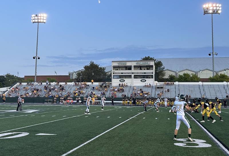 Players from the St. Bede and Tuscola football teams play the opening snap on Friday, Aug. 25, 2023 at Tucci Stadium  in Bloomington.