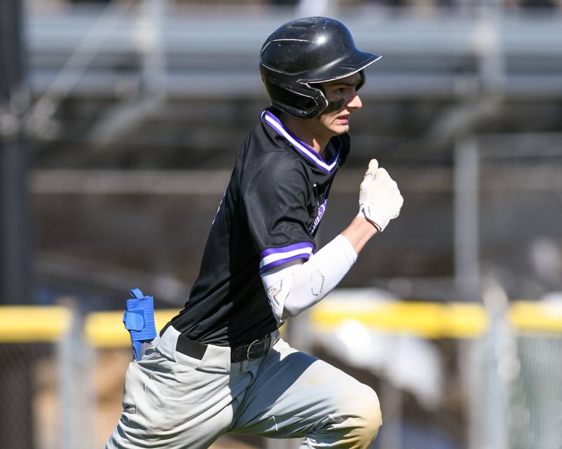 Downers Grove North’s Jude Warwick tries to beat the throw to first in April 2024 while traveling to take on Downers Grove South.