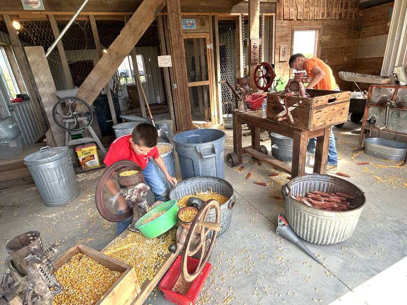 The 16th Annual AJ’s Garden Tractor Jamboree on Saturday, May 17, 2025 included activities for kids. Here, Quintin Walton, 8, and Rayden Applequist, 13, of Dixon, shell corn by hand in one of the farm's barns.