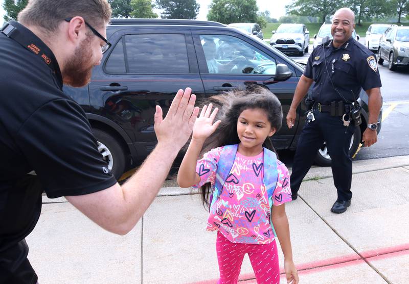 DeKalb School District 428 board member Christopher Boyes and DeKalb Police Chief David Byrd greet students Thursday, Aug. 17, 2023, as they arrive for the first day of the new school year at Gwendolyn Brooks Elementary School in DeKalb.
