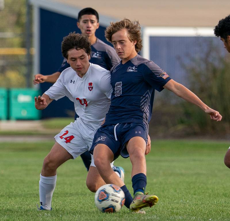 Oswego’s Noah Abbas (24) challenges Oswego East's Dylan Drendel (6) for the ball during a soccer match at Oswego East High School on Monday, Sep 26, 2022.