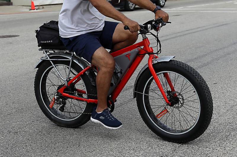 A man rides an electric bicycle across Illinois Route 31 in McHenry on Friday, Aug. 15, 2025.